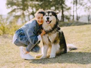 Lady hugging large dog outside