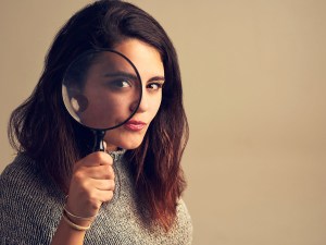 Woman looking through a magnifying glass